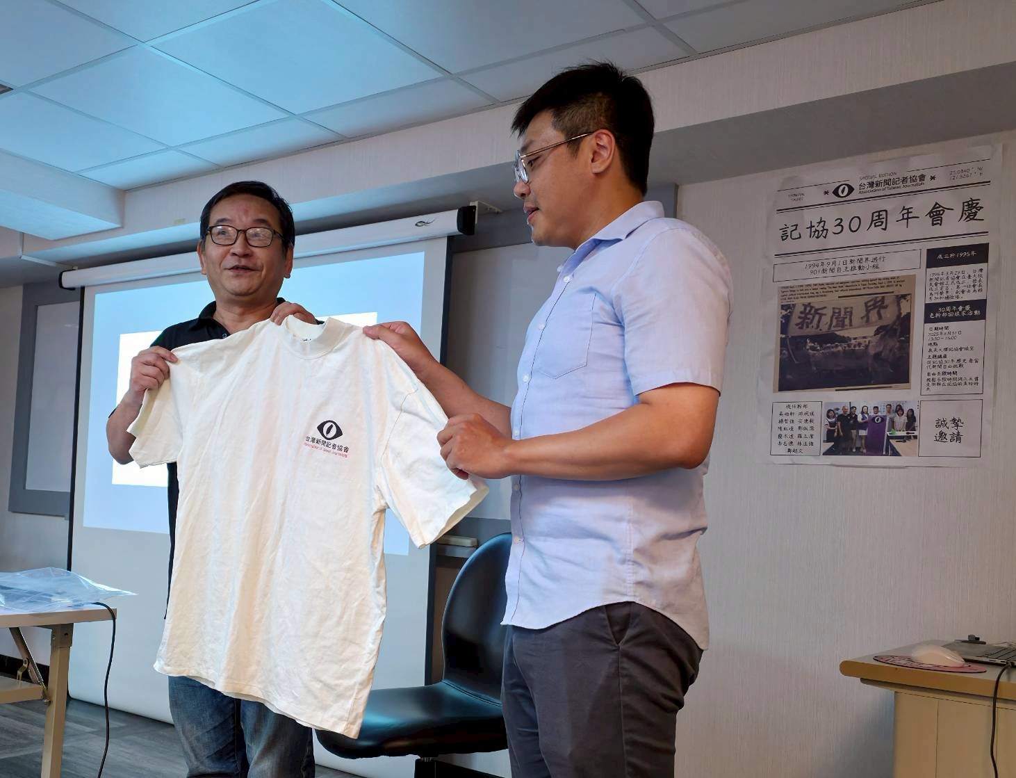 前任執委及秘書長邱奕嵩致贈早年記協t恤給現任會長吳柏軒，望記協精神能夠傳承